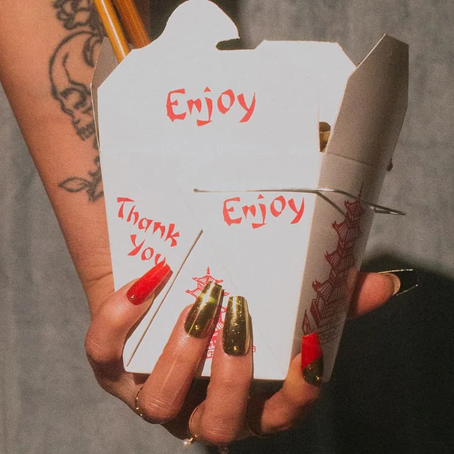 A red and gold chrome set holding an open takeout carton.